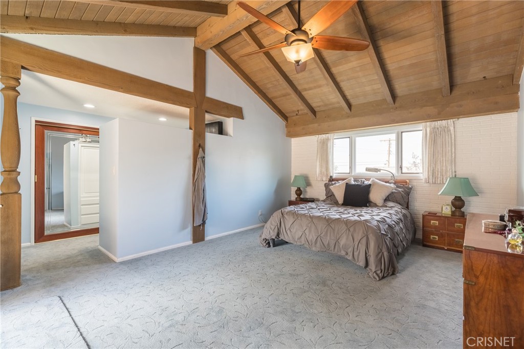 10610 Walnut Drive Shadow Hills, CA 91040 - Photo 19 of 50 a spacious bedroom with a bed and a chandelier