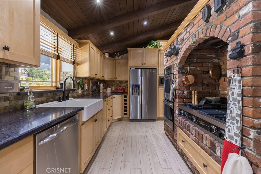 10610 Walnut Drive Shadow Hills, CA 91040 - Photo 7 of 50 a kitchen with stainless steel appliances kitchen island granite countertop a stove a sink and a refrigerator