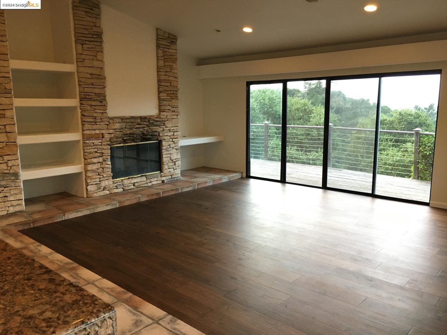 25435 Hidden Mesa Road Monterey, CA 93940 - Photo 2 of 8 a view of empty room with wooden floor and fireplace