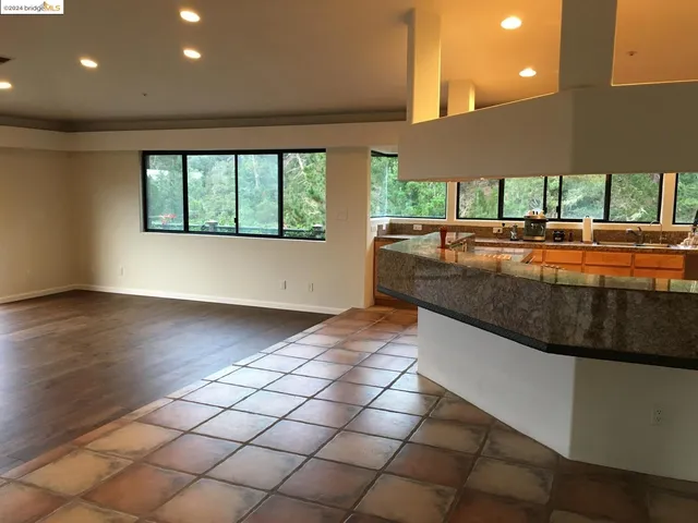 a view of a kitchen with kitchen island a large window and a sink