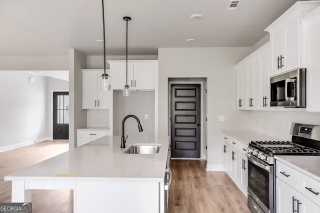a kitchen with stainless steel appliances kitchen island a stove a sink and a refrigerator