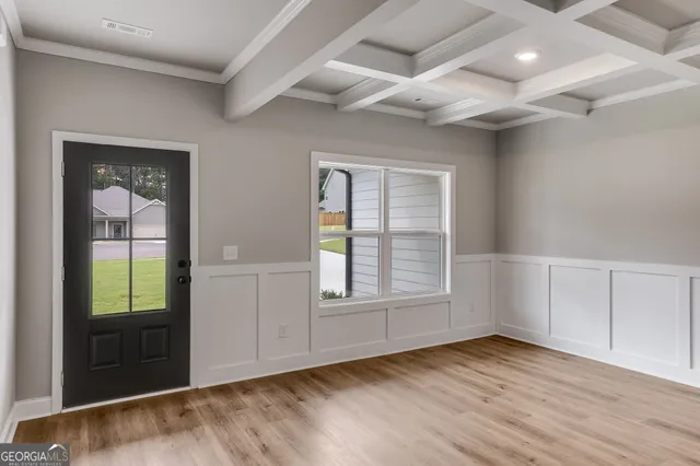 an empty room with wooden floor and windows