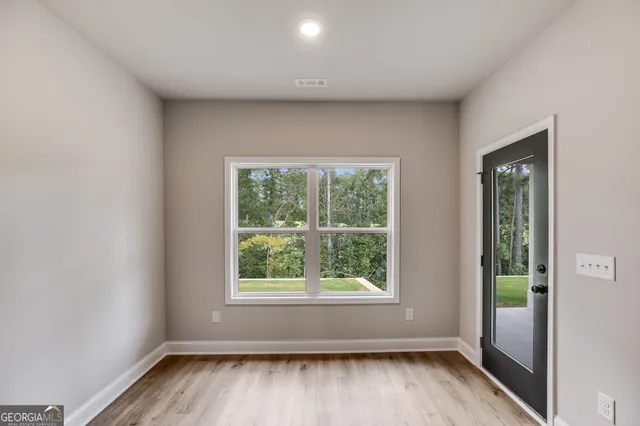 an empty room with wooden floor and windows