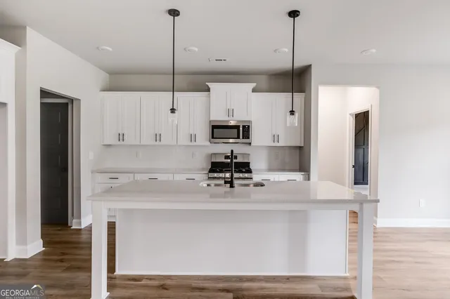 a kitchen with kitchen island a counter top space appliances and cabinets
