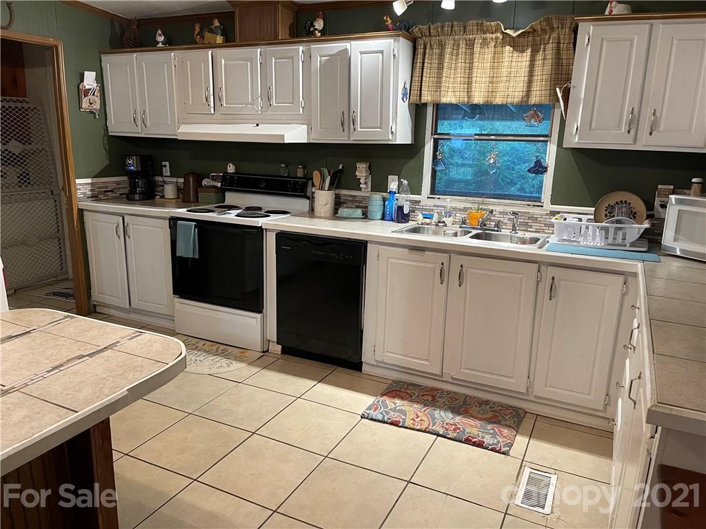 141 Allen Loop Road Rutherfordton, NC 28139 - Photo 21 of 30 a kitchen with a sink a stove top oven a counter space and cabinets