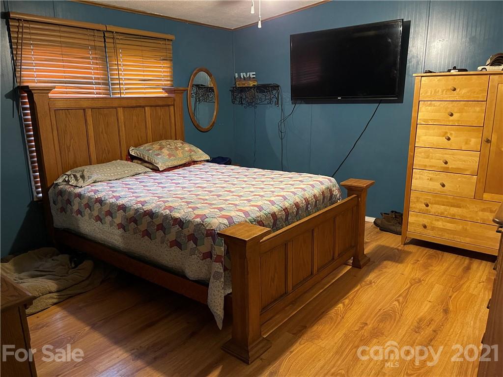 141 Allen Loop Road Rutherfordton, NC 28139 - Photo 22 of 30 a bedroom with a bed a dresser and flat screen tv