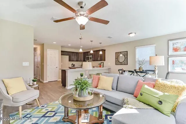 a living room with furniture kitchen and a chandelier