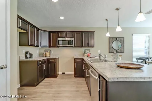 a kitchen with stainless steel appliances granite countertop a sink stove and cabinets