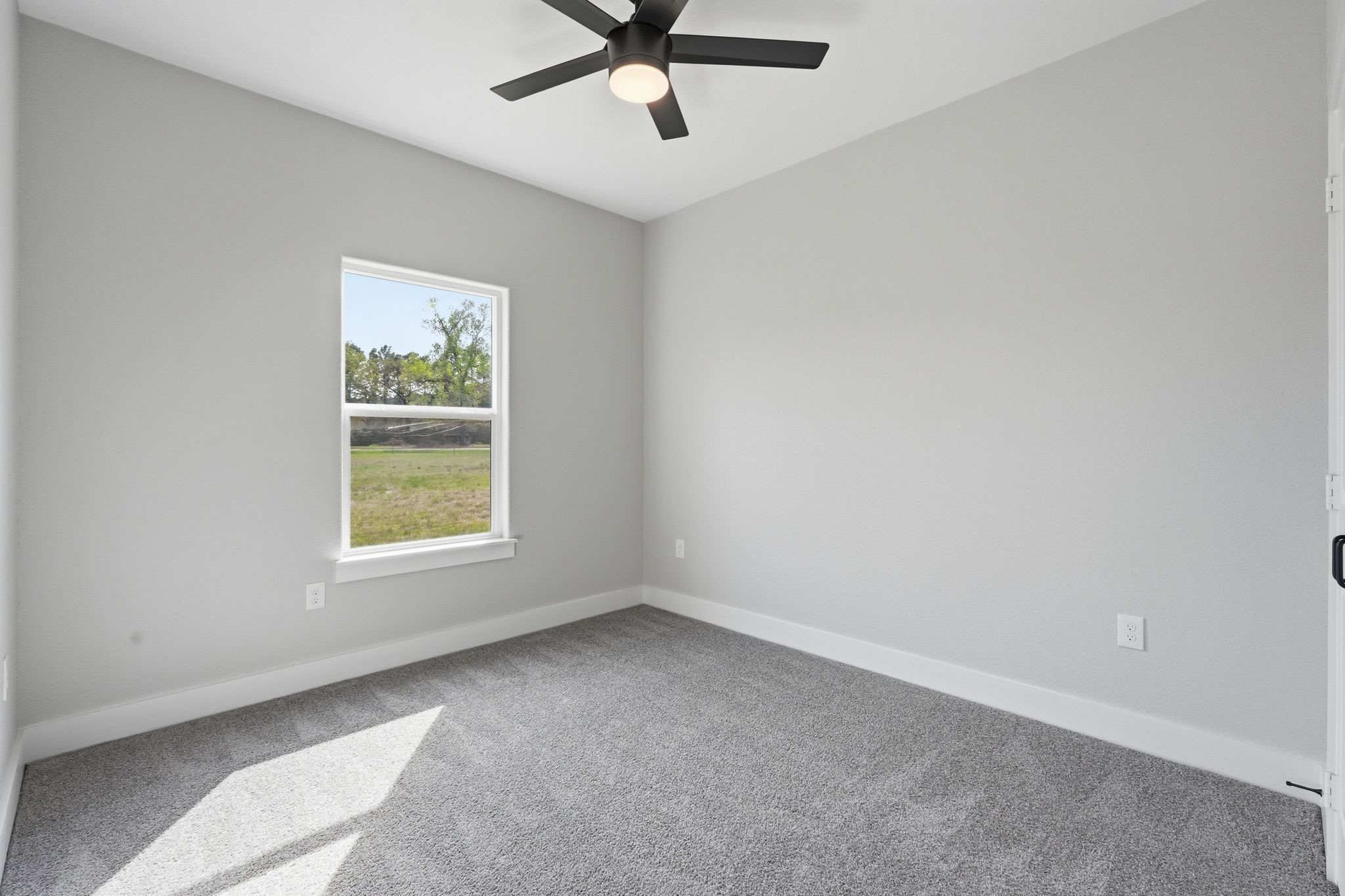 44 Meadow Lake Drive Trinity, TX 75862 - Photo 27 of 39 an empty room with a window and a ceiling fan