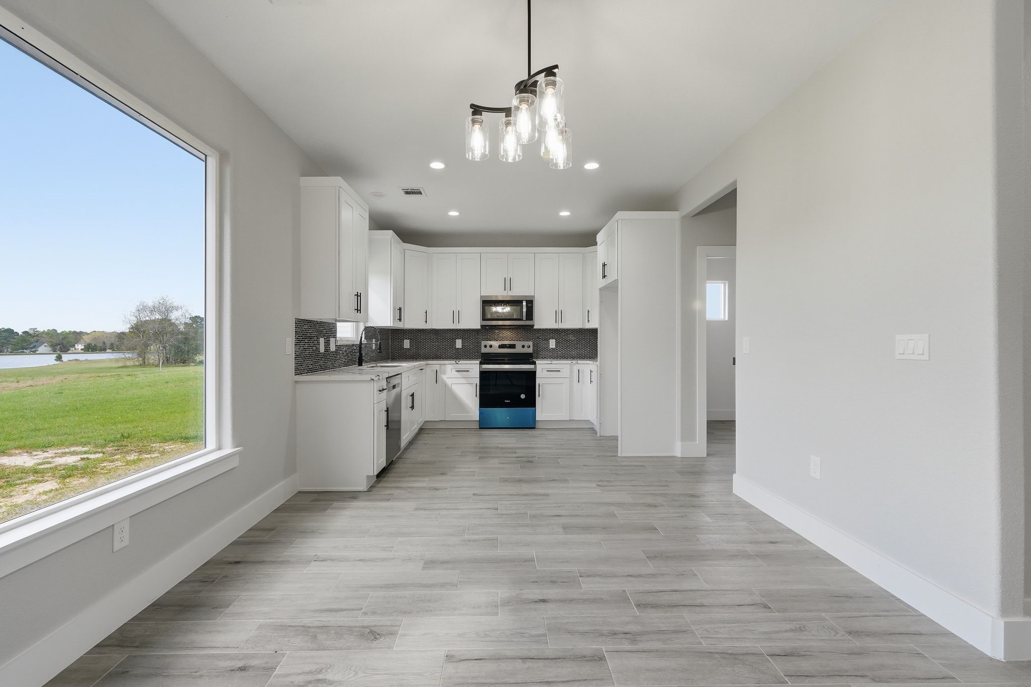 44 Meadow Lake Drive Trinity, TX 75862 - Photo 9 of 39 a kitchen with stainless steel appliances granite countertop a refrigerator a stove top oven a sink dishwasher and white cabinets with wooden floor