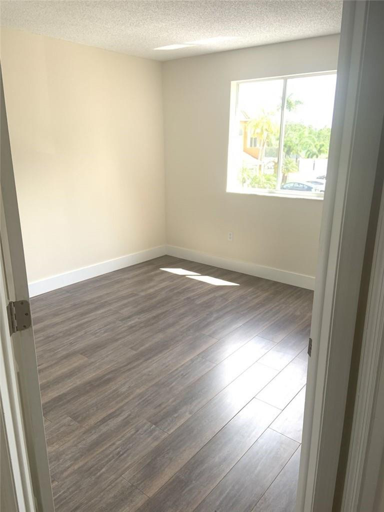 13402 Southwest 153rd Street, Unit 1901 Miami, FL 33177 - Photo 11 of 17 an empty room with wooden floor and windows