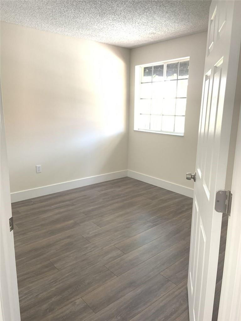 13402 Southwest 153rd Street, Unit 1901 Miami, FL 33177 - Photo 12 of 17 an empty room with wooden floor and windows