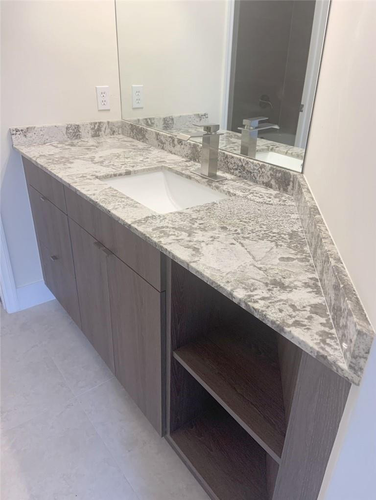 13402 Southwest 153rd Street, Unit 1901 Miami, FL 33177 - Photo 15 of 17 a bathroom with a granite countertop sink and a mirror
