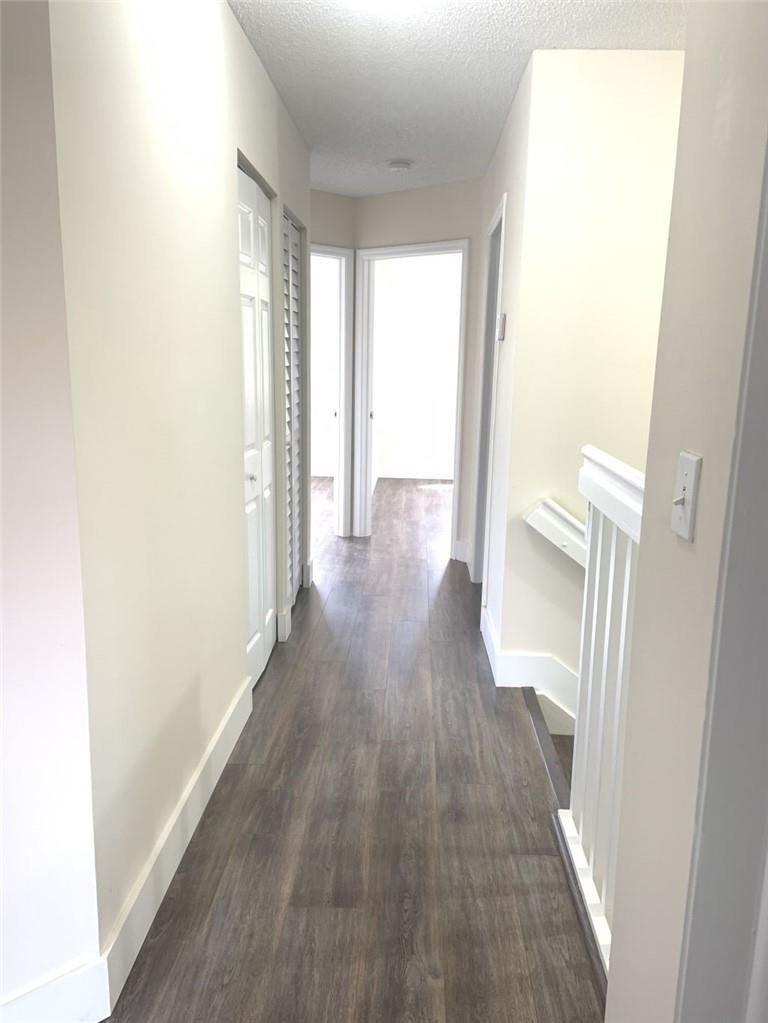 13402 Southwest 153rd Street, Unit 1901 Miami, FL 33177 - Photo 8 of 17 a view of a hallway with wooden floor and a bathroom