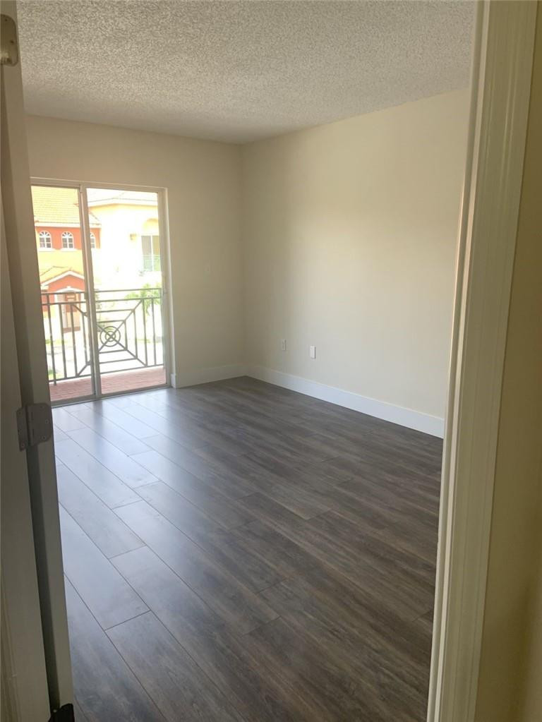 13402 Southwest 153rd Street, Unit 1901 Miami, FL 33177 - Photo 9 of 17 a view of an empty room with wooden floor and a window