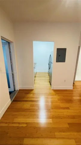 a view of an empty room with wooden floor