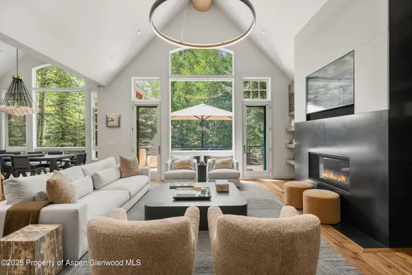 a living room with furniture a large window and a fireplace
