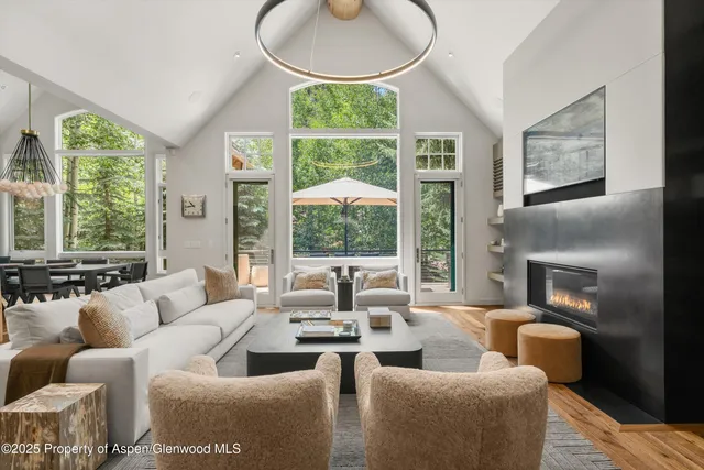 a living room with furniture a large window and a fireplace