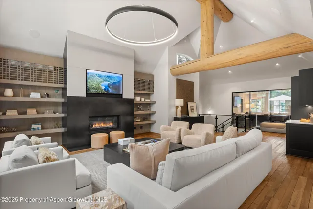 a living room with furniture a fireplace and a large window