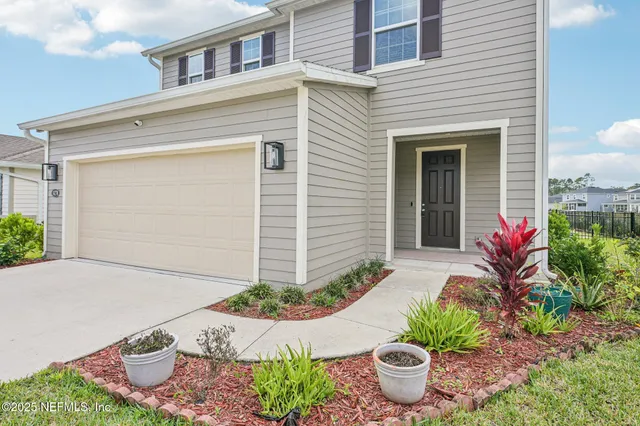 a large kitchen with kitchen island a stove a sink a refrigerator and white cabinets