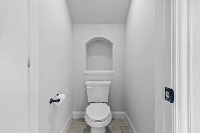 a white toilet sitting in a bathroom next to a sink
