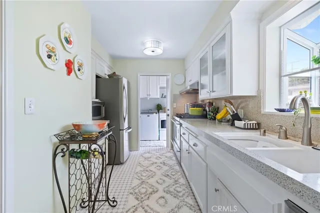 a kitchen with stainless steel appliances granite countertop a refrigerator and a stove