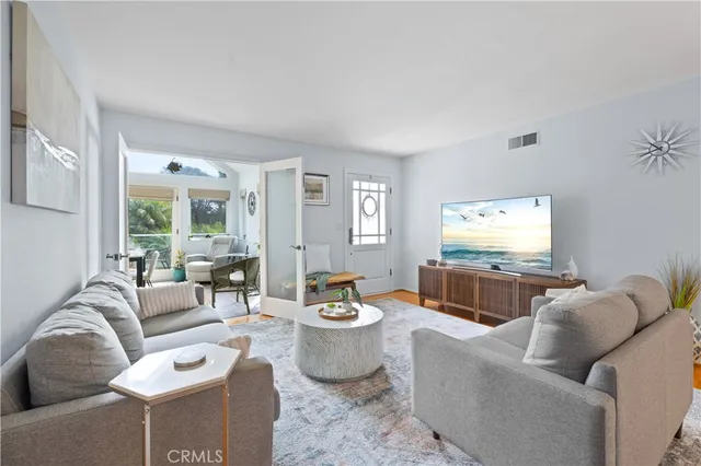 a living room with furniture a large window and a dining table