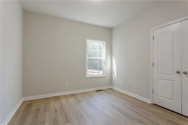 an empty room with wooden floor and window