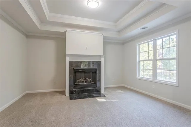 an empty room with a fireplace and windows