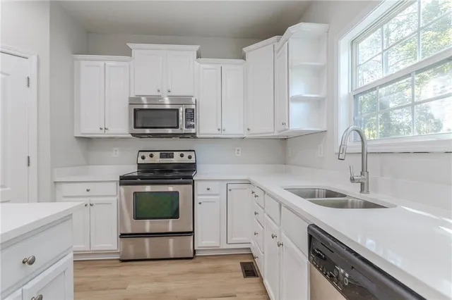 a kitchen with stainless steel appliances granite countertop a sink and a stove