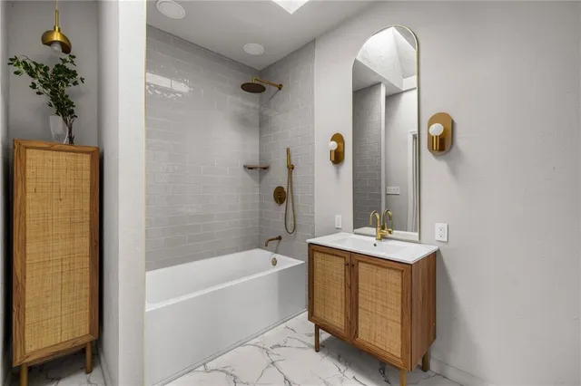 a bathroom with a tub sink and mirror