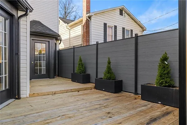 a backyard of a house with potted plants and wooden fence
