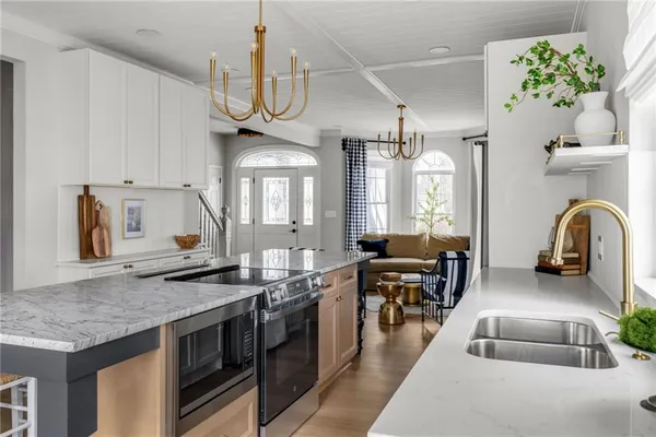 a kitchen with granite countertop a sink a stove and cabinets