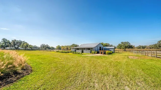 a view of swimming pool with seating area and trees in the background