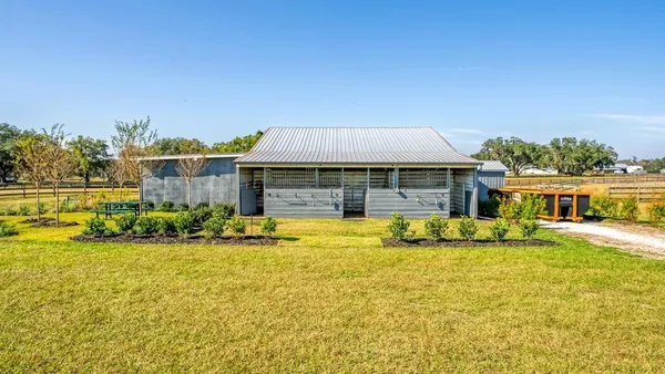 a view of swimming pool with seating area and trees in the background