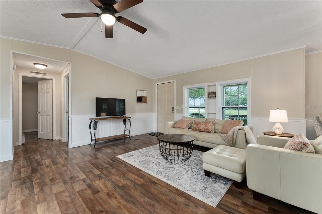 15305 Northwest 112th Place Road Morriston, FL 32668 - Photo 49 of 95 a living room with furniture and a flat screen tv