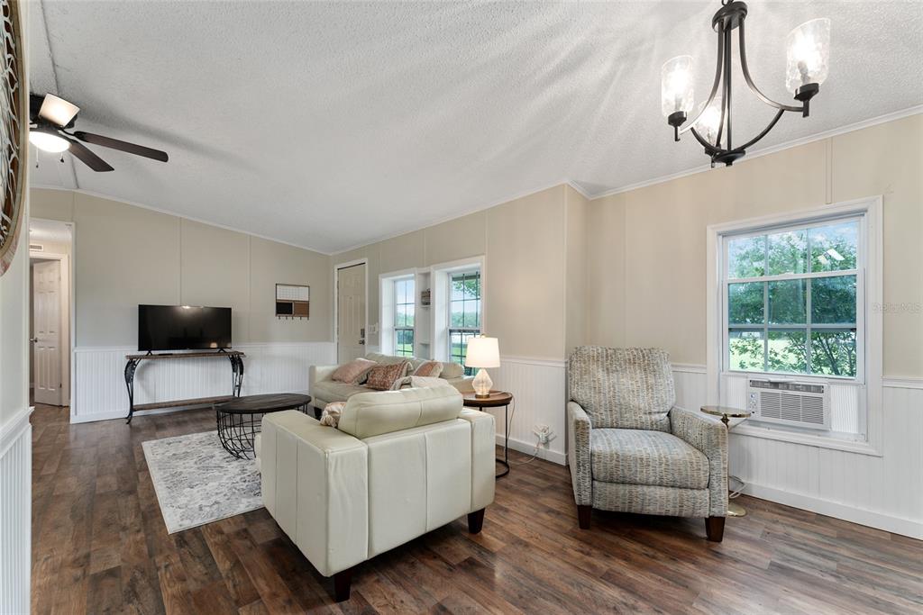 15305 Northwest 112th Place Road Morriston, FL 32668 - Photo 51 of 95 a living room with furniture a flat screen tv and a window