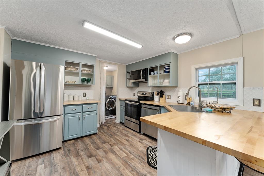 15305 Northwest 112th Place Road Morriston, FL 32668 - Photo 53 of 95 a kitchen with granite countertop a refrigerator stove and sink