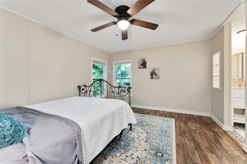 15305 Northwest 112th Place Road Morriston, FL 32668 - Photo 61 of 95 a bedroom with a bed and a chandelier