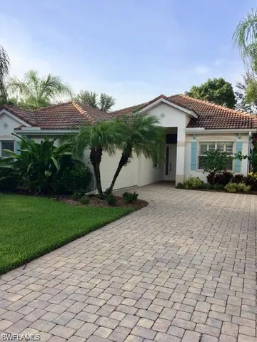 a view of a house with a yard and potted plants