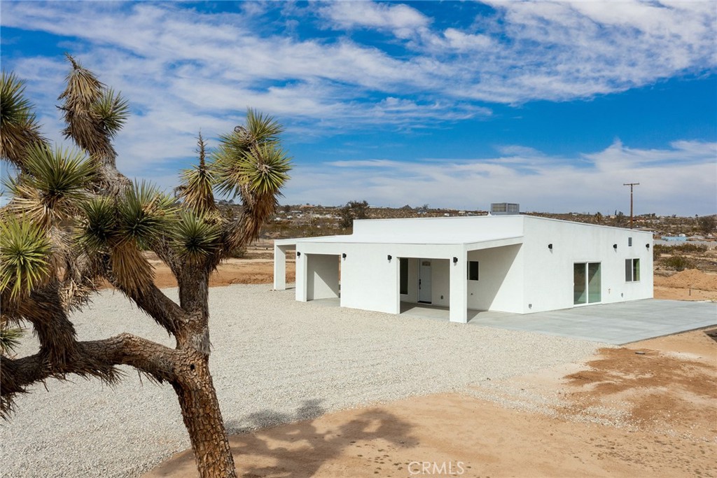 62474 Golden Street Joshua Tree, CA 92252 - Photo 1 of 31 a view of a white house with a yard