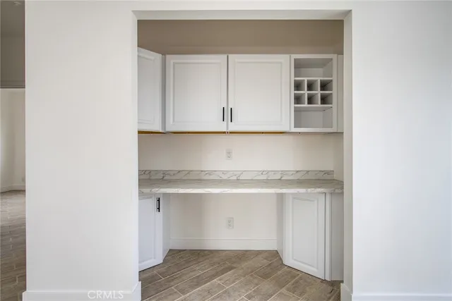 a large white kitchen with a white stove top oven and white cabinets