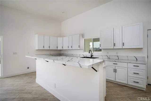 a kitchen with stainless steel appliances white cabinets sink and a stove
