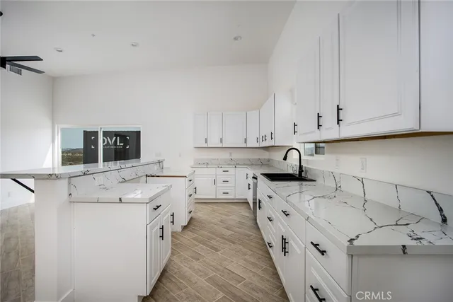 a kitchen with stainless steel appliances granite countertop white cabinets sink and window