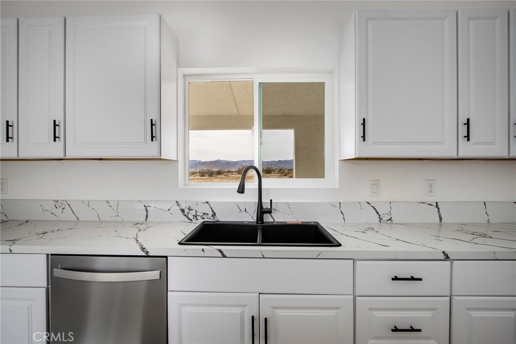 62474 Golden Street Joshua Tree, CA 92252 - Photo 18 of 31 a kitchen with stainless steel appliances granite countertop white cabinets sink and window