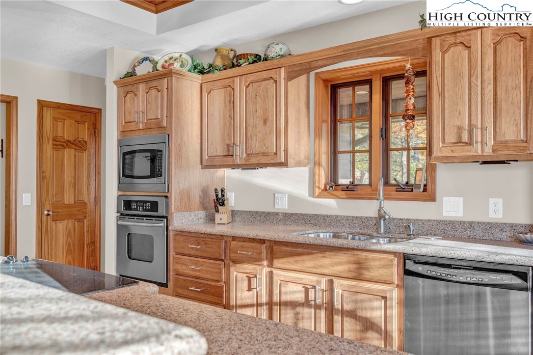 121 Spruce Hollow Road Beech Mountain, NC 28604 - Photo 13 of 50 a kitchen with stainless steel appliances granite countertop a refrigerator and a sink