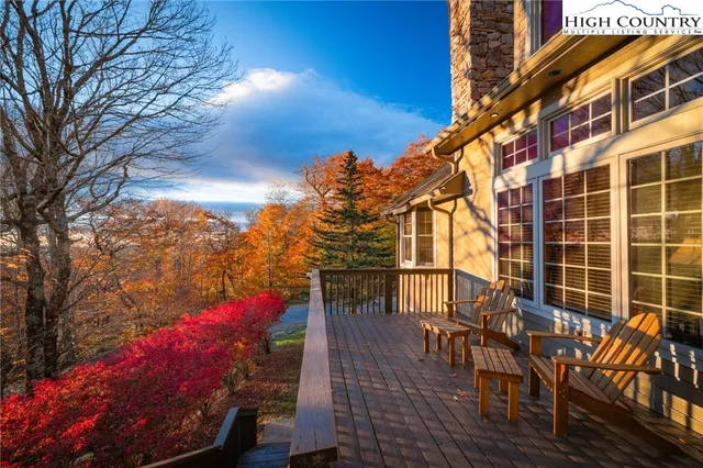 a view of a patio with table and chairs and potted plants with wooden floor and fence