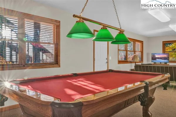 a room with pool table and windows