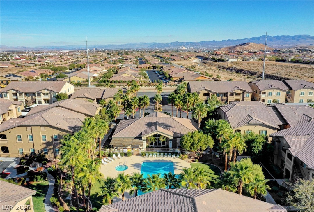 8985 South Durango Drive, Unit 2187 Las Vegas, NV 89113 - Photo 48 of 73 An aerial perspective reveals a serene community pool with spa, surrounded by swaying palm trees and desert-inspired landscaping.