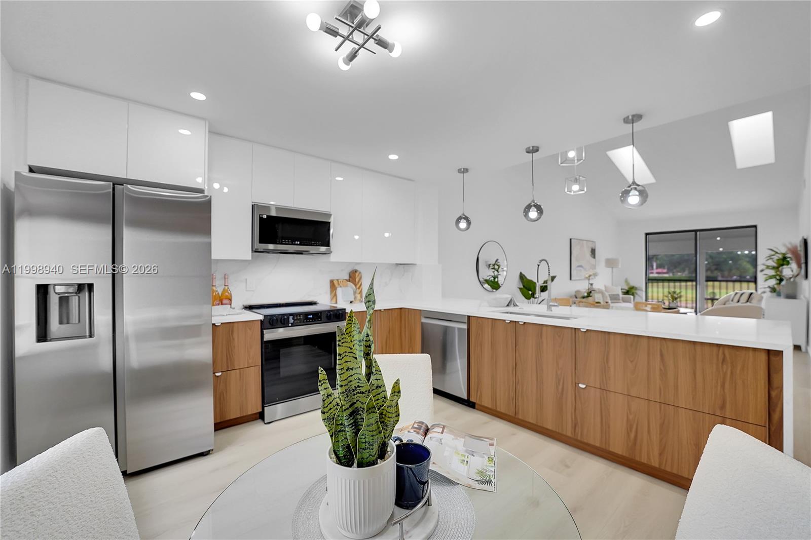 7736 La Mirada Drive Boca Raton, FL 33433 - Photo 1 of 56 a kitchen with stainless steel appliances a refrigerator a sink a stove a microwave a dining table and chairs